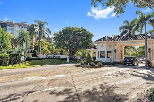 view of front facade featuring driveway, a carport, a tiled roof, and stucco siding