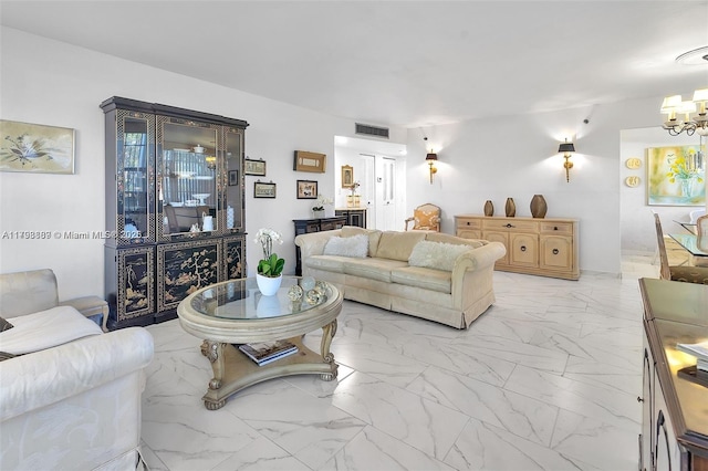 living area featuring a chandelier and light marble finish flooring