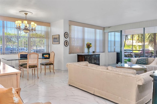 living area with marble finish floors and a chandelier