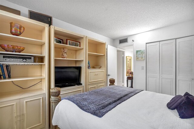 bedroom with a textured ceiling and a closet