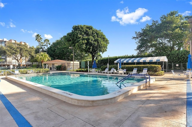 community pool with fence and a patio