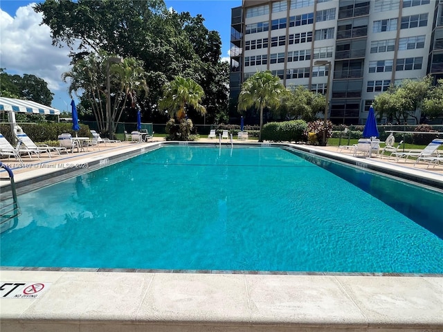 community pool featuring fence and a patio