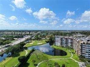 drone / aerial view of apartment complex, a large body of water, and a golf course