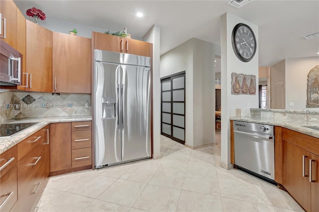 12672 Tucano Cir, Boca Raton, FL 33428 - kitchen featuring stainless steel appliances, light stone countertops, brown cabinetry, decorative backsplash, and recessed lighting