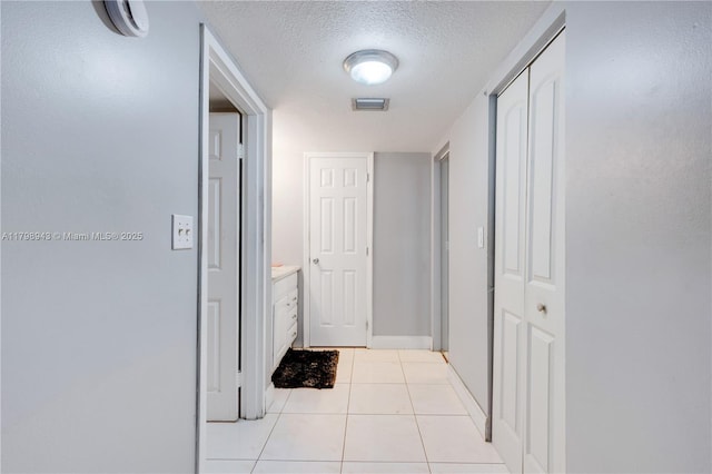 4848 NW 24th Ct Unit 215, Lauderdale Lakes, FL 33313 - hall featuring tile patterned flooring, a textured ceiling, and baseboards