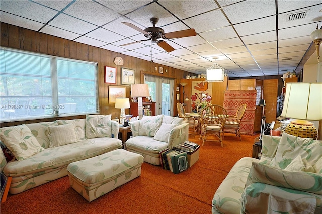 10610 SW 103rd St, Miami, FL 33176 - living room featuring plenty of natural light, wooden walls, a ceiling fan, carpet flooring, and a drop ceiling