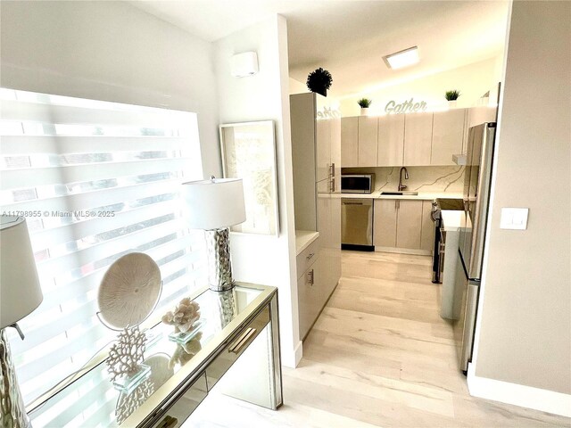 2406 Marathon Ln, Fort Lauderdale, FL 33312 - kitchen with stainless steel appliances, a sink, light countertops, light wood-style floors, and tasteful backsplash