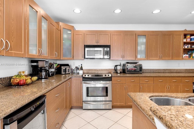 151 Crandon Blvd Unit 926, Key Biscayne, FL 33149 - kitchen featuring appliances with stainless steel finishes, light tile patterned floors, light stone counters, glass insert cabinets, and recessed lighting