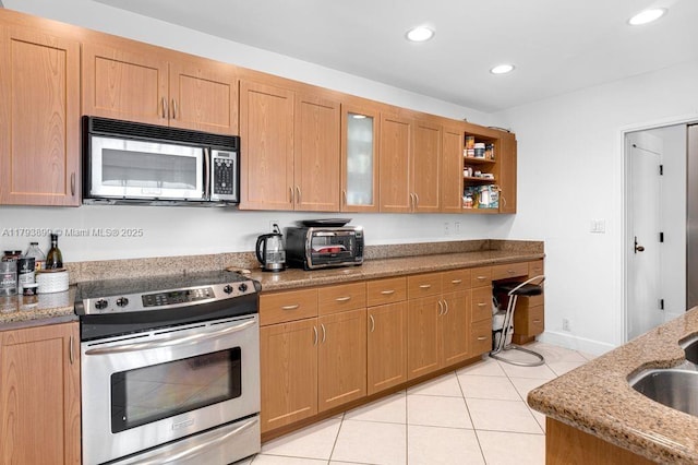151 Crandon Blvd Unit 926, Key Biscayne, FL 33149 - kitchen featuring appliances with stainless steel finishes, light tile patterned flooring, light stone countertops, recessed lighting, and glass insert cabinets