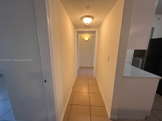 corridor with light tile patterned floors and baseboards