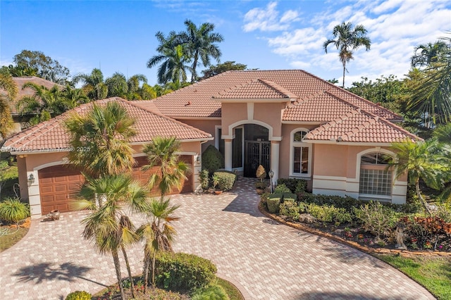 8100 Muirhead Cir, Boynton Beach, FL 33472 - mediterranean / spanish house with a garage, stucco siding, a tiled roof, and decorative driveway