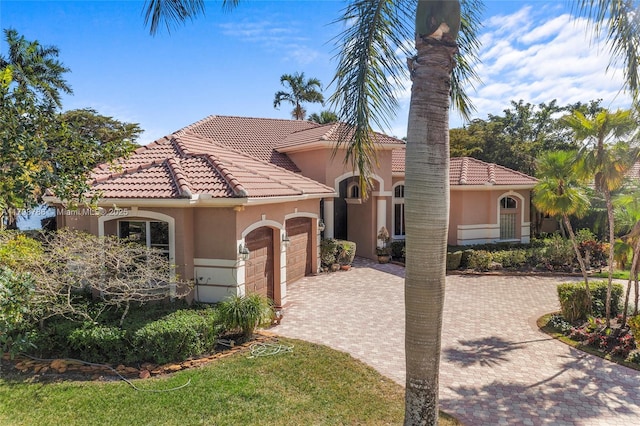 8100 Muirhead Cir, Boynton Beach, FL 33472 - mediterranean / spanish-style house with an attached garage, stucco siding, a tile roof, and decorative driveway