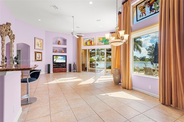 8100 Muirhead Cir, Boynton Beach, FL 33472 - interior space featuring built in shelves, light tile patterned flooring, a kitchen breakfast bar, arched walkways, and recessed lighting