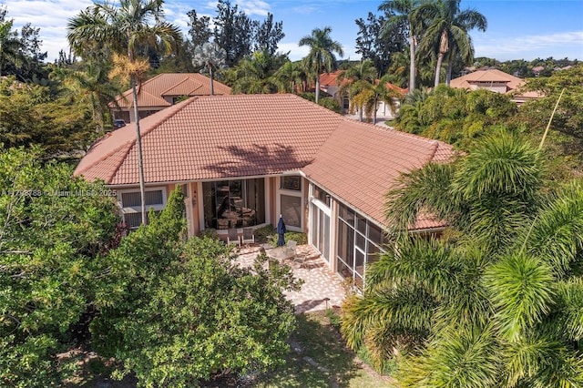 8100 Muirhead Cir, Boynton Beach, FL 33472 - view of front of property featuring a tile roof, a sunroom, a patio area, and stucco siding