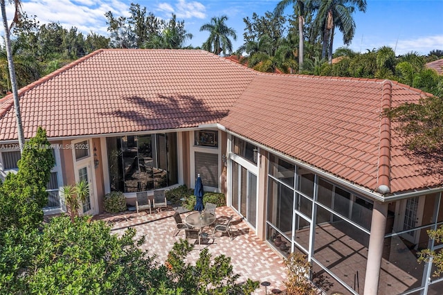 8100 Muirhead Cir, Boynton Beach, FL 33472 - rear view of property with a tiled roof, a patio, and a sunroom