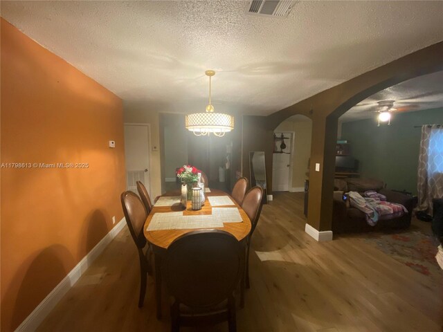 8130 SW 7th Ct, North Lauderdale, FL 33068 - dining room featuring wood finished floors, a ceiling fan, arched walkways, baseboards, and a textured ceiling