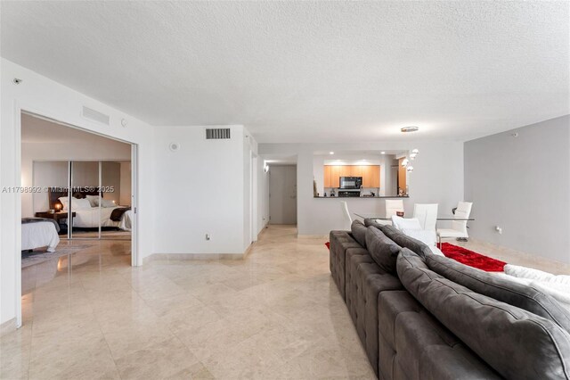 6917 Collins Ave Unit 607, Miami Beach, FL 33141 - living area with a textured ceiling and baseboards