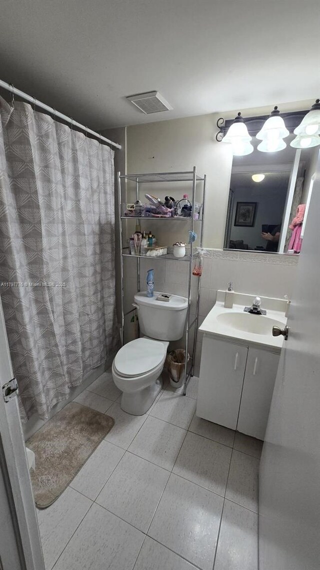 6425 SW 130th Pl Unit 704, Miami, FL 33183 - full bathroom featuring tile patterned floors, tile walls, vanity, toilet, and curtained shower