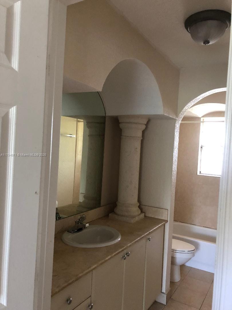full bathroom with toilet, tile patterned flooring, and vanity
