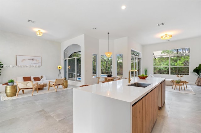 10275 Oak Meadow Ln, Lake Worth, FL 33449 - kitchen featuring a sink, modern cabinets, light countertops, an island with sink, and decorative light fixtures