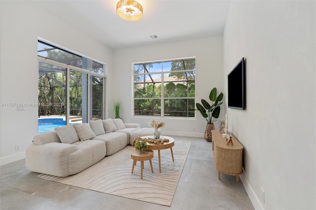 10275 Oak Meadow Ln, Lake Worth, FL 33449 - living area featuring baseboards, finished concrete floors, and a sunroom