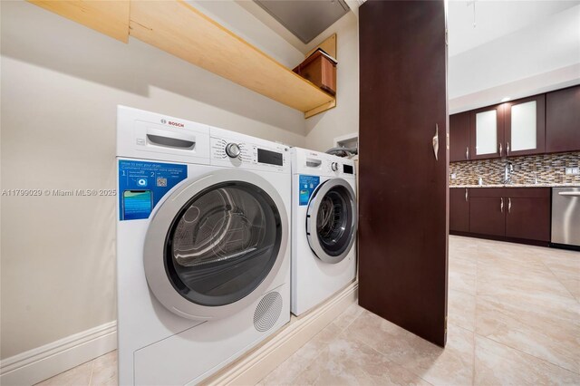 9801 Collins Ave Unit 5S, Bal Harbour, FL 33154 - washroom featuring washing machine and clothes dryer, light tile patterned floors, and baseboards