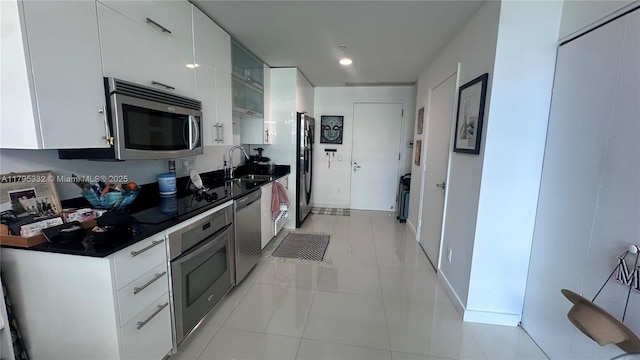 60 SW 13th St Unit 2402, Miami, FL 33130 - kitchen featuring appliances with stainless steel finishes, a sink, dark countertops, white cabinets, and light tile patterned floors