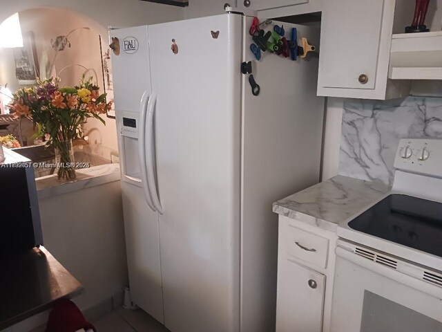 2791 N Pine Island Rd Unit 301, Sunrise, FL 33322 - kitchen with white appliances, white cabinets, and backsplash