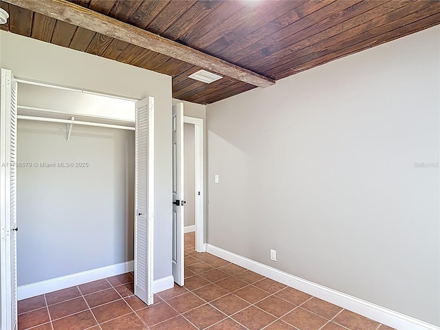 10227 SW 53rd Ct, Cooper City, FL 33328 - unfurnished bedroom with dark tile patterned floors, beamed ceiling, wood ceiling, baseboards, and a closet