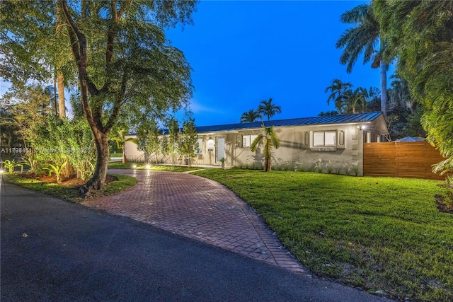 615 NE 115th St, Biscayne Park, FL 33161 - view of front facade with decorative driveway, metal roof, stucco siding, and a standing seam roof