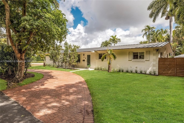 615 NE 115th St, Biscayne Park, FL 33161 - single story home featuring stucco siding, metal roof, curved driveway, and a standing seam roof