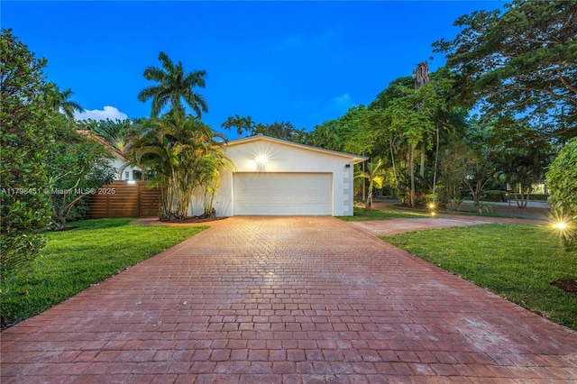 615 NE 115th St, Biscayne Park, FL 33161 - view of front facade featuring decorative driveway, an attached garage, stucco siding, and a front lawn