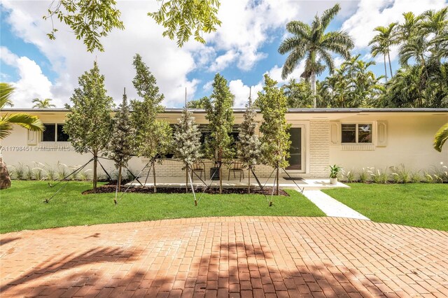 615 NE 115th St, Biscayne Park, FL 33161 - single story home featuring stucco siding, a patio area, and a front lawn
