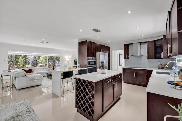 615 NE 115th St, Biscayne Park, FL 33161 - kitchen featuring a sink, wall chimney range hood, appliances with stainless steel finishes, open floor plan, and light countertops