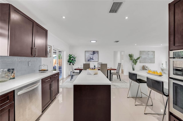 615 NE 115th St, Biscayne Park, FL 33161 - kitchen with stainless steel appliances, a kitchen island, recessed lighting, dark brown cabinets, and light countertops
