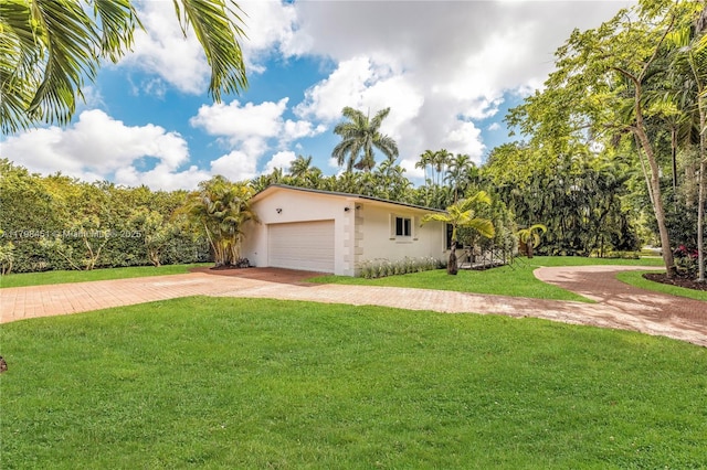 615 NE 115th St, Biscayne Park, FL 33161 - view of side of home featuring a yard, stucco siding, driveway, and an attached garage