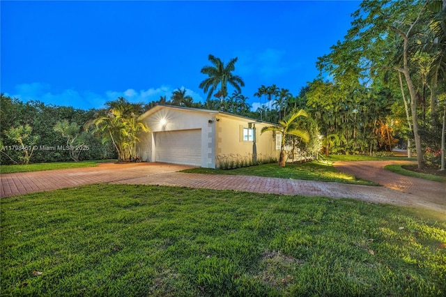 615 NE 115th St, Biscayne Park, FL 33161 - view of front of property with driveway, stucco siding, a front yard, and an attached garage
