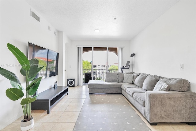 living area with light tile patterned flooring and a textured ceiling