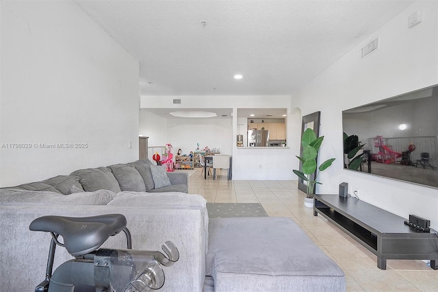 tiled living room featuring recessed lighting and a textured ceiling