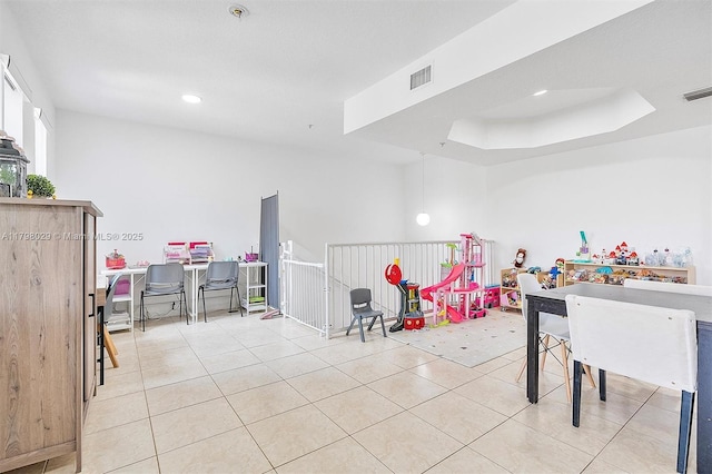 game room with tile patterned floors, recessed lighting, and a tray ceiling