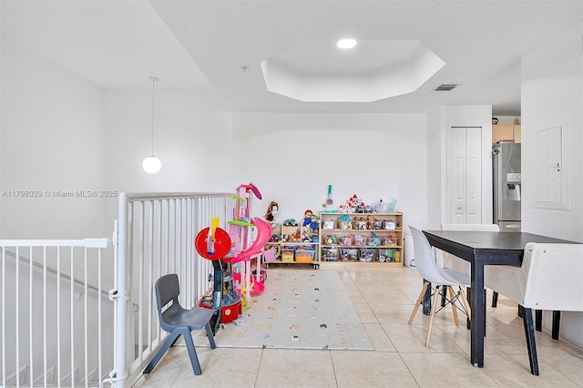 recreation room with a tray ceiling and light tile patterned floors