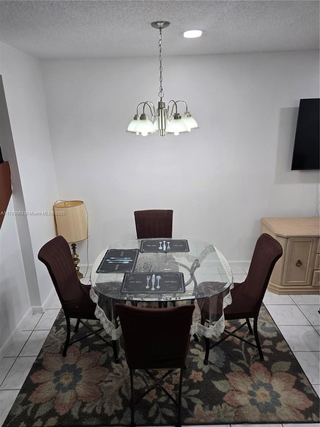 dining space with a chandelier, a textured ceiling, and baseboards