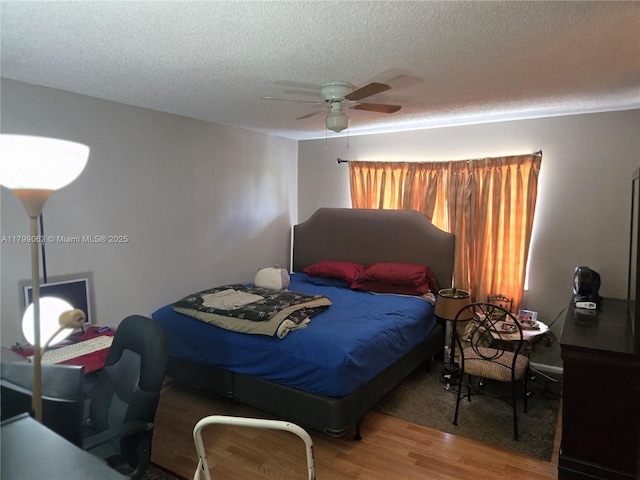 bedroom featuring wood finished floors, a textured ceiling, and ceiling fan