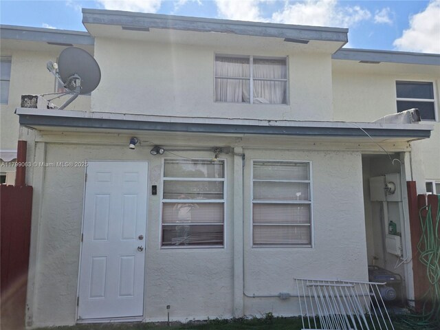 view of front of home with stucco siding and fence