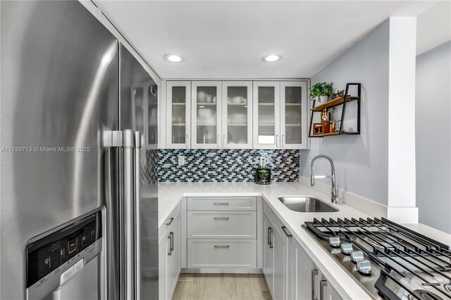 2201 Brickell Ave Unit 77, Miami, FL 33129 - kitchen with stainless steel appliances, a sink, recessed lighting, light countertops, and glass insert cabinets