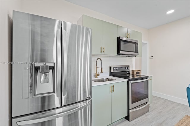 1824 NW 47th St, Miami, FL 33142 - kitchen with appliances with stainless steel finishes, a sink, light wood-type flooring, baseboards, and light countertops