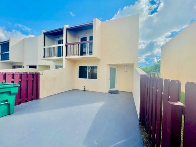 3672 SW 59th Ave Unit 7, Davie, FL 33314 - back of property featuring stucco siding, fence, a balcony, and a patio area