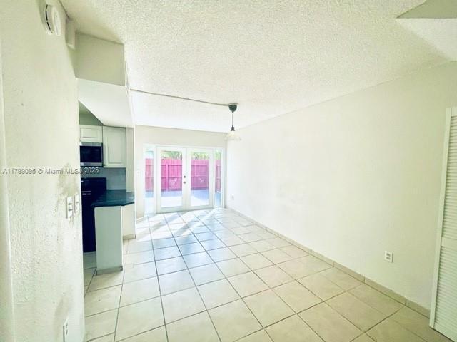 3672 SW 59th Ave Unit 7, Davie, FL 33314 - empty room featuring french doors, a textured ceiling, and light tile patterned floors