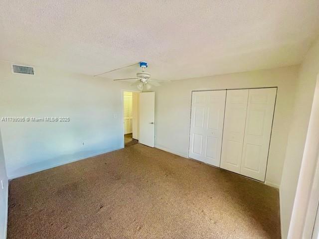 3672 SW 59th Ave Unit 7, Davie, FL 33314 - unfurnished bedroom featuring a closet, a ceiling fan, carpet flooring, and a textured ceiling