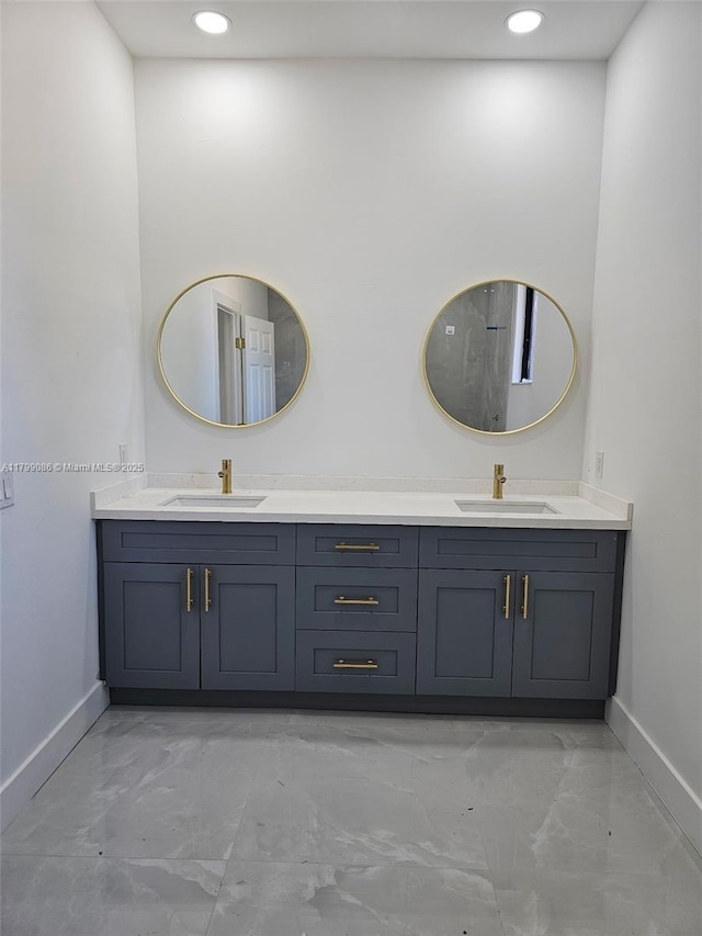 bathroom featuring baseboards, marble look tile flooring, double vanity, and recessed lighting